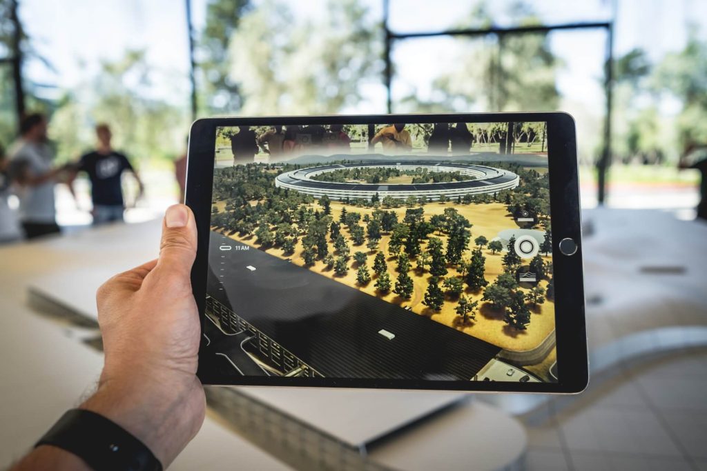 guy holding iPad viewing architecture/landscape via augmented reality.