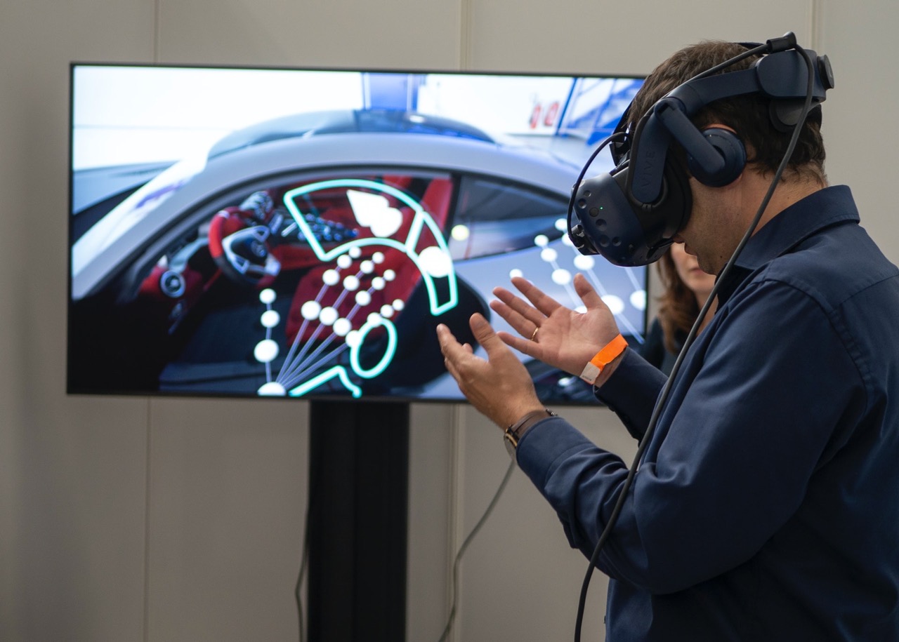 Man using Virtual Reality goggles for Design concepts in Automotive. Screen shows car with VR controls