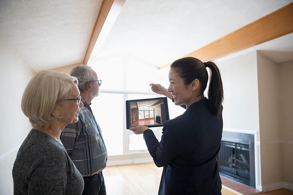 Woman showing Old Couple an Application of Virtual Reality in the Interior Design/Real Estate Industry.